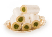 A stack of white cylindrical sweets with green filling, presented on a plate.