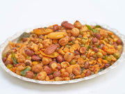A plate of Navadhaniyam Mixture, which appears to be a spicy snack made of mixed nuts and possibly some herbs.