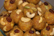 A close-up of mini Thirupathi laddu garnished with cashew nuts and raisins.