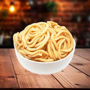A bowl of Thenkualal Murukku, a type of Indian snack, displayed on a wooden table with a blurred background.
