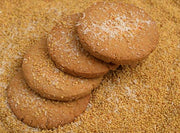 Thinai Biscuits placed on a bed of raw millet grains, focusing on the texture and simplicity of the biscuits.