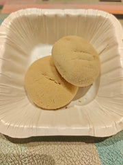 Two biscuits placed on a white disposable plate.