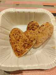 Two heart-shaped cookies on a white plate.