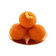 Three Motichoor Laddu sweets placed on a round golden plate against a white background.