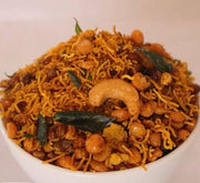 A bowl of Inji Mixture, featuring crispy noodles mixed with chickpeas, cashew nuts, and seasoned with spices, garnished with curry leaves.